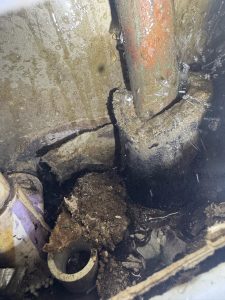 Water spraying out of a copper pipe sleeve indicating a slab leak in Pinellas County.