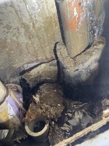Water spraying out of a sleeve around a 3/4" copper pipe.
