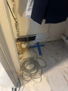 An blue X on the floor marking the location of a slab leak in Pinellas County.